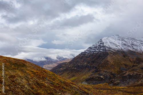 View of Scenic Landscape and Mountains in Canadian Nature. Season change from Fall to Winter. Taken near Grizzly Lake in Tombstone Territorial Park, Yukon, Canada.