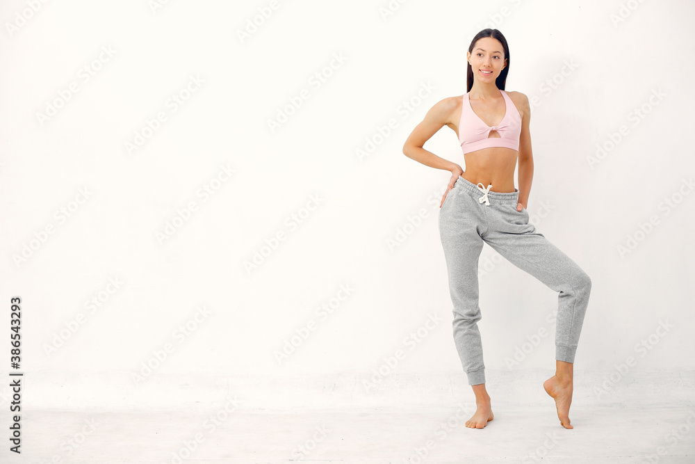 Fototapeta premium Beautiful girl in yoga studio. A woman doing a yoga. Lady in a pink top.