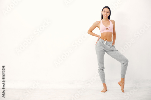 Beautiful girl in yoga studio. A woman doing a yoga. Lady in a pink top.