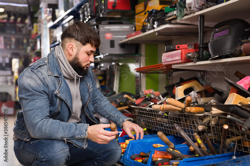 Adult consumer is choosing various hand tools in store