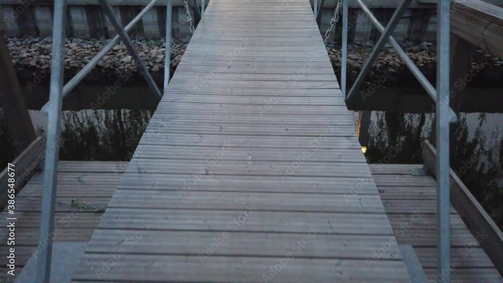 Walking on a pontoon on lake.Wooden structure on water. Walking on a pontoon on lake.Wooden structure on water.