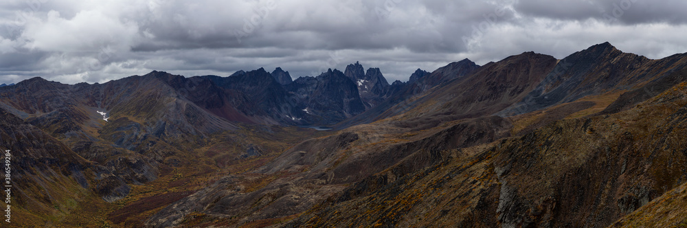Panoramic View of Scenic Landscape and Mountains on a Cloudy Fall Day in Canadian Nature. Taken in Tombstone Territorial Park, Yukon, Canada. Panoramic View of Scenic Landscape and Mountains on a Cloudy Fall Day in Canadian Nature. Taken in Tombstone Territorial Park, Yukon, Canada.