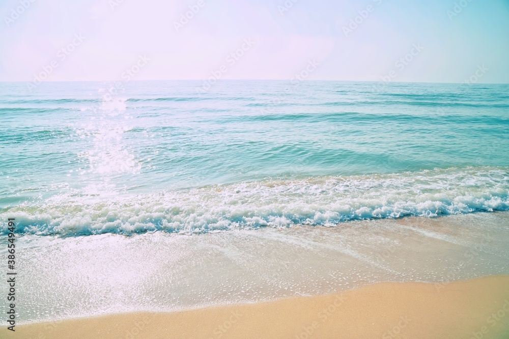 Emerald color of sea water on beach in morning light. Beautiful nature background.