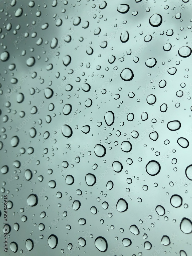 Image of water droplets on a clear glass surface during heavy rain. Image of water droplets on a clear glass surface during heavy rain.
