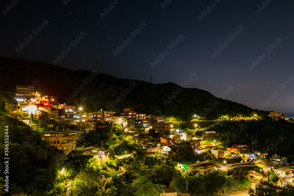 Jiufen village at night with mountain and ocrean view.