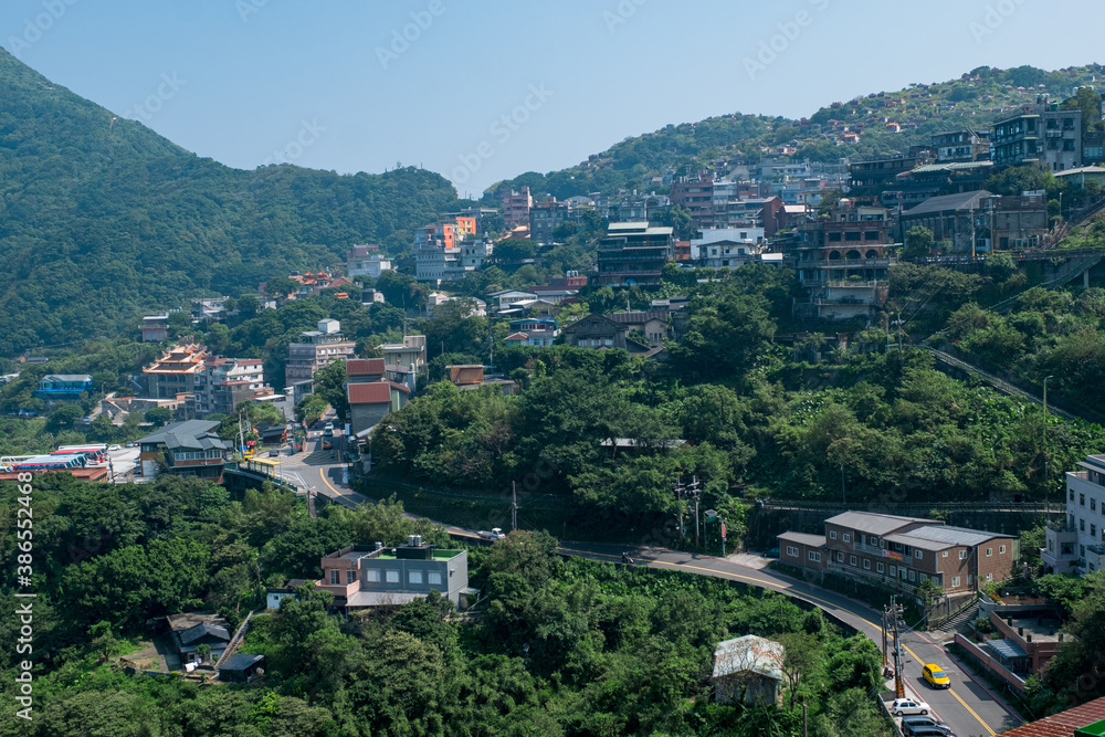 landscape view of JiuFen Village with mountain residental buildings and blue sky.