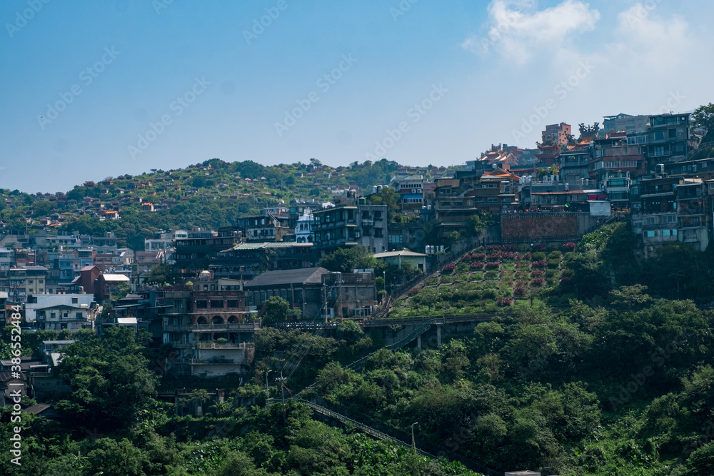 landscape view of JiuFen Village with mountain residental buildings and blue sky.