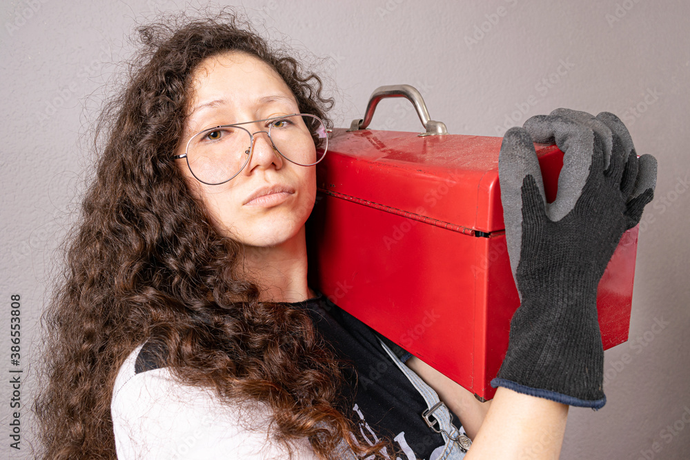 Retrato de mujer constructora con gafas sosteniendo una caja de