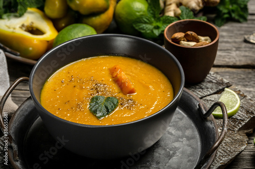 Vegetarian autumn pumpkin cream soup with baked peppers and cheese, lime juice and ginger