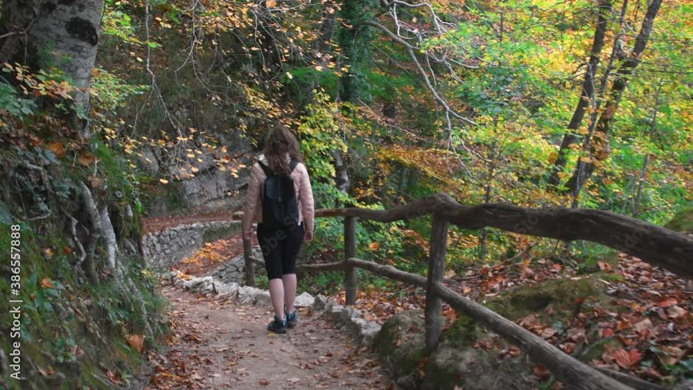 Autumn Plitvice Lakes, National Park in Croatia, UNESCO world heritage. Woman trekking on wooden trail Autumn Plitvice Lakes, National Park in Croatia, UNESCO world heritage. Woman trekking on wooden trail