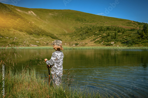 Teenager tourist in mountain lake looking at beautiful view in Carpathians