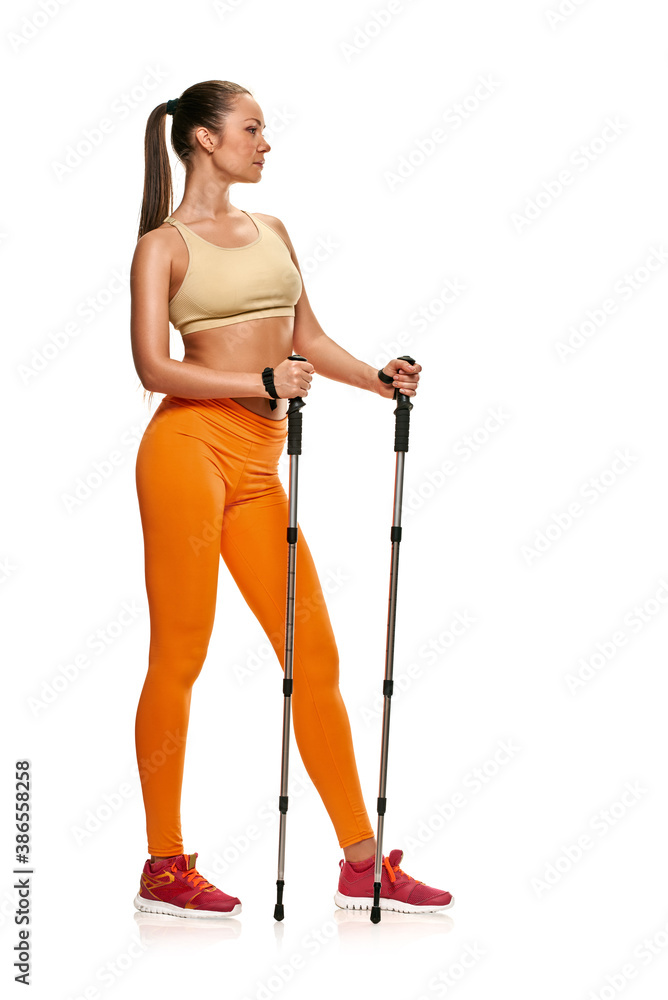 Young healthy woman practising nordic walking on white background