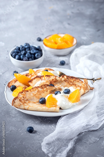 Crepes with yoghurt, berries and peaches