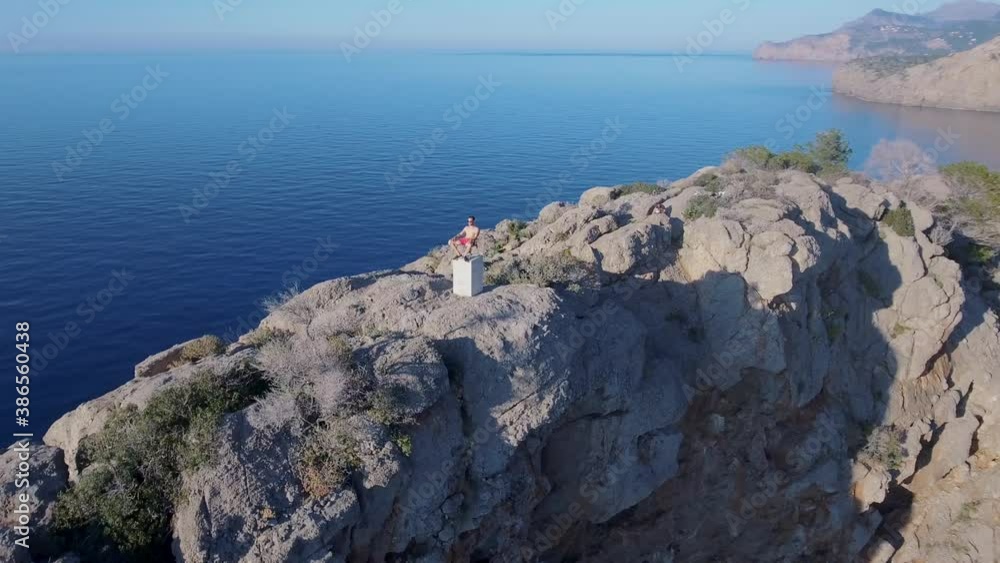 4k aerial view of man sitting on a folding chair on a cliff and enjoys the ocean view and his freedom in an unreal location - Enjoy life and be free - Mallorca Serra de Tramuntana 4k aerial view of man sitting on a folding chair on a cliff and enjoys the ocean view and his freedom in an unreal location - Enjoy life and be free - Mallorca Serra de Tramuntana