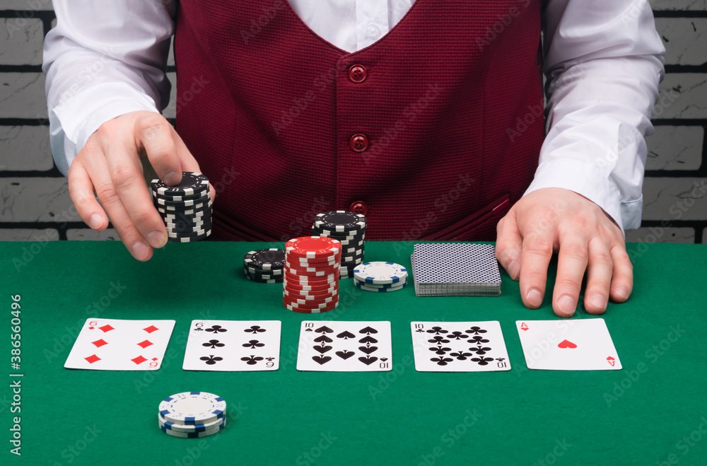 the croupier opened the cards in the game of poker and raises the stakes with chips the croupier opened the cards in the game of poker and raises the stakes with chips