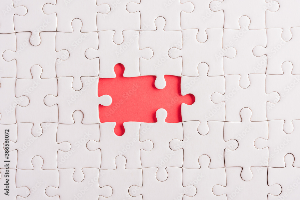 Top view flat lay of paper plain white jigsaw puzzle game texture incomplete or missing piece, studio shot on a red background, quiz calculation concept Top view flat lay of paper plain white jigsaw puzzle game texture incomplete or missing piece, studio shot on a red background, quiz calculation concept
