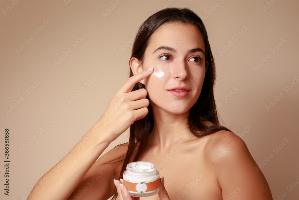 Joven Mujer mexicana aplicando crema humectante facial producto de belleza  - obrazy, fototapety, plakaty 