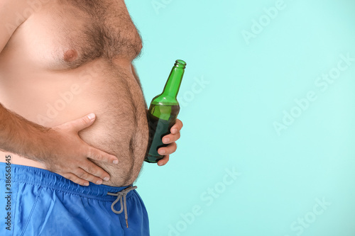 Overweight man with beer on...