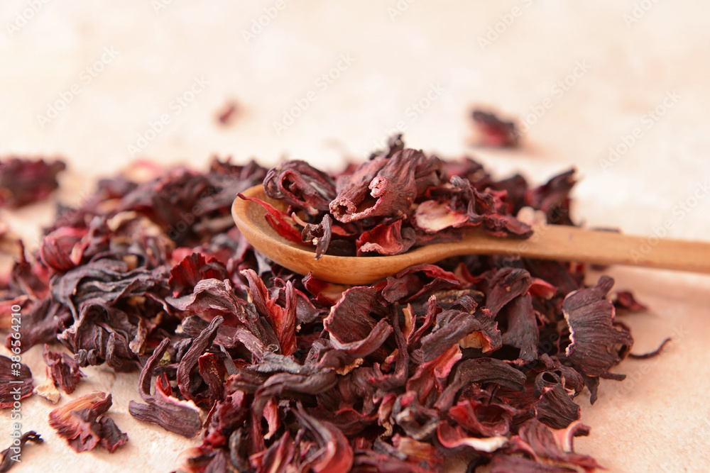 Spoon with dry hibiscus tea on table, closeup Spoon with dry hibiscus tea on table, closeup