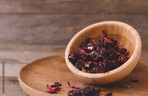 Bowl with dry hibiscus tea on table