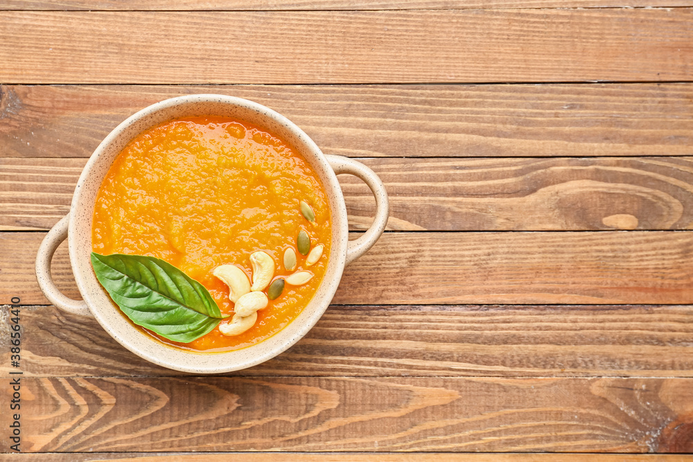 Tasty pumpkin cream soup in pot on table Tasty pumpkin cream soup in pot on table
