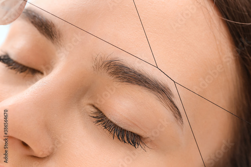 Canvas Print Young woman undergoing eyebrow correction procedure in beauty salon, closeup