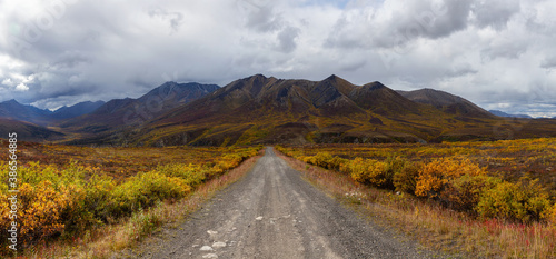 Panoramic View of Scenic Road and Mountains on a Cloudy Fall Day in Canadian Nature. Taken near Tombstone Territorial Park, Yukon, Canada.