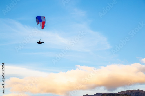 Paraglider flying Up High surrounded by Clouds in Canadian Nature. Taken in Tombstone Territorial Park, Yukon, Canada.