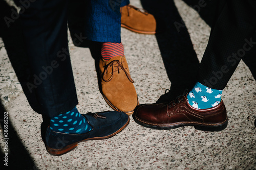 Groom's and groomsman feet with funny colorful socks. The men in stripy socks. Bright, vintage, brown shoes. Fashion, style, beauty.