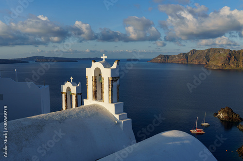 Arch with a bell, white church in Oia, Santorini, Greece.