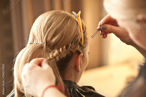 Closeup hairdresser coiffeur makes hairstyle for bride.