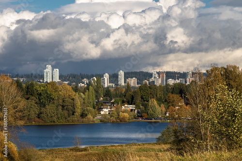 Fototapeta Naklejka Na Ścianę i Meble -  Residential area near Deer Lake Park in Burnaby, the construction of three skyscrapers in the area against the Stormy Cloudy Sky