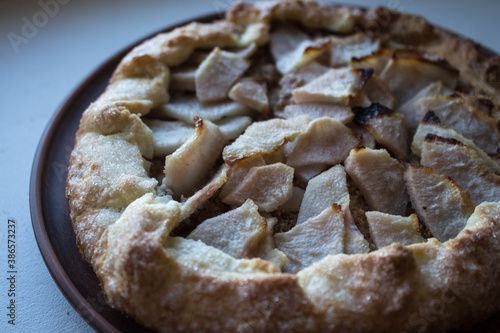 a pear pie on a clay plate