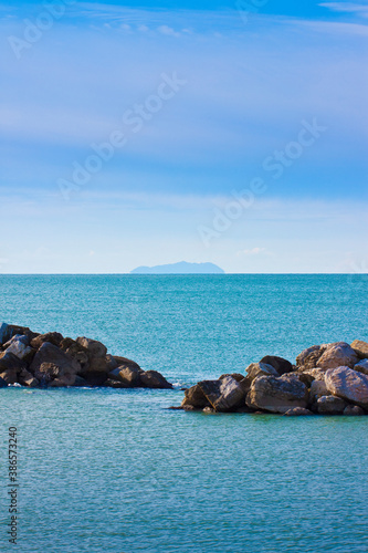 Seascape with small island on background and rock on foreground - image with copy space © Francesco Scatena