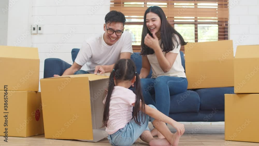 Happy Asian young family homeowners bought new house. Korean Mom, Dad, and daughter playing together during unpacking in new home after moving in relocation sitting on floor with boxes together. Happy Asian young family homeowners bought new house. Korean Mom, Dad, and daughter playing together during unpacking in new home after moving in relocation sitting on floor with boxes together.