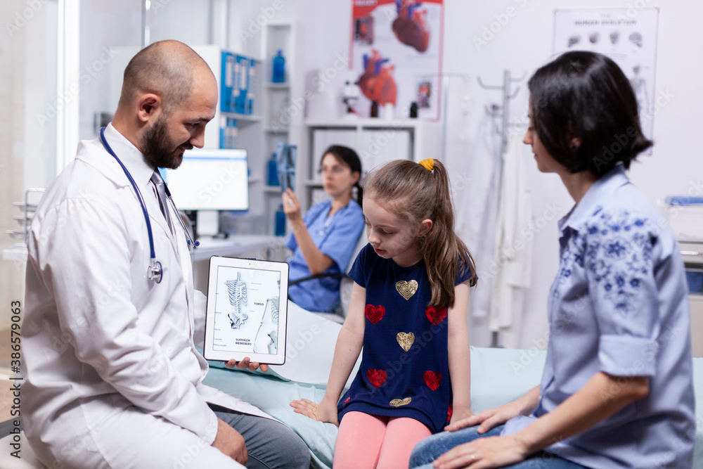Obraz premium Doctor talking about diagnosis with mother of sick child in hospital office. Healthcare physician specialist in medicine providing health care services treatment examination.