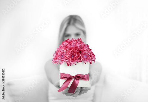 Canvas Print A young blonde is holding a bouquet of red chrysanthemum flowers in a decorative box