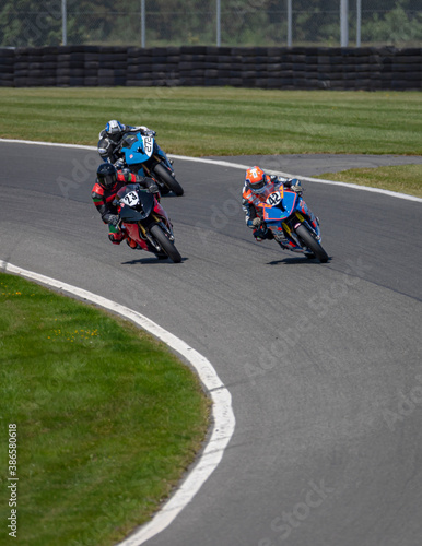 A shot of several racing bikes cornering on a track.