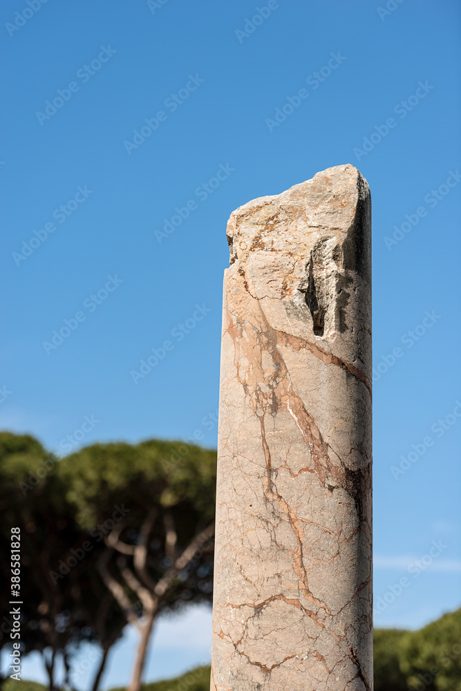 Roman marble broken column on a clear blue sky, Ostia Antica Archeological Site, colony founded in the 7th century B.C. near Rome, UNESCO world heritage site. Latium, Italy, Europe.