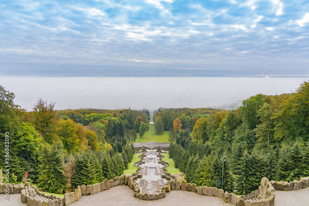 The stairs with its water basins of the famous water features in the mountain park in Kassel, Germany, morning mist lies over the city