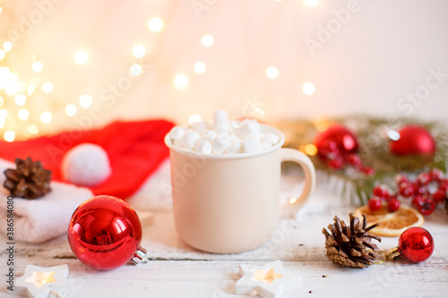 Christmas background,  coffee mug and marshmallows , red Christmas toys, glowing lights . Merry Christmas greeting card
