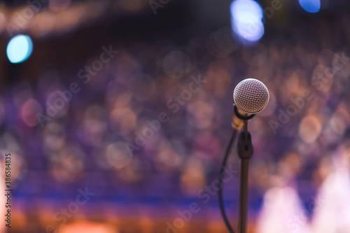 Close up of microphone over abstract blurred of attendee in seminar room or conference hall