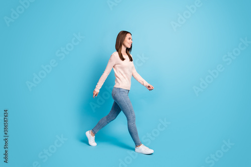 Full length body size profile side view of her she nice attractive pretty thin cheerful brown-haired girl walking isolated over bright vivid shine vibrant blue color background