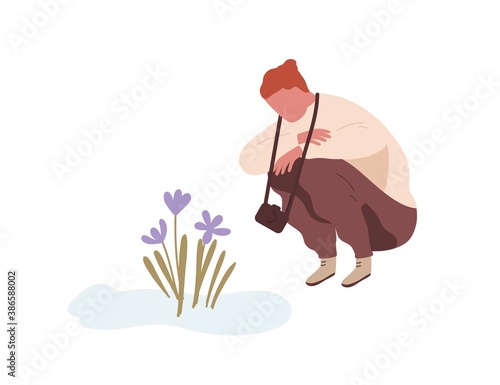 Squatting man admiring first spring flower or snowdrop. Teenager with camera sitting and looking at primrose. Flat vector cartoon illustration isolated on white background