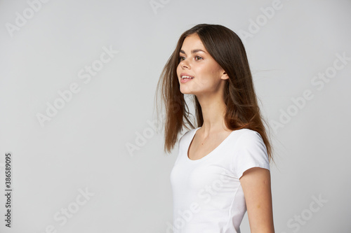 a woman in a white T-shirt looking forward and smiling