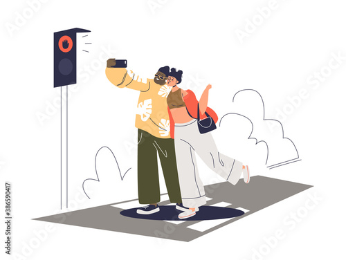 Couple taking selfie photo on crosswalk on road with red street light. Dangerous selfie concept