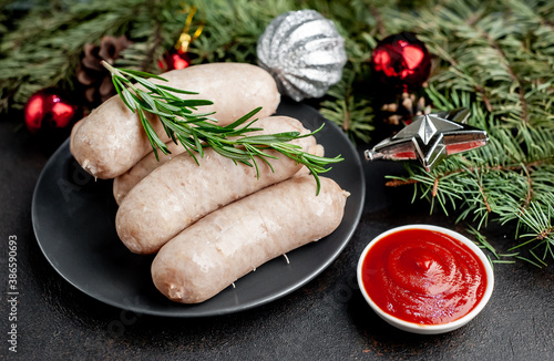 Christmas sausages with spices on a stone background with Christmas trees and Christmas decorations, gifts