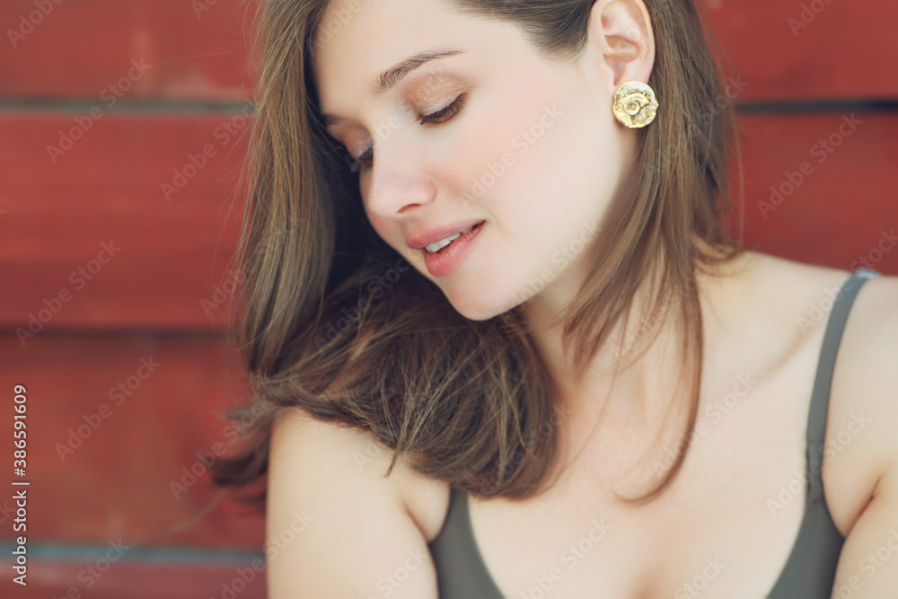Close-up of a beautiful woman in shiny gold earrings. Portrait of a young woman in costume jewelry. High quality photo. Close-up of a beautiful woman in shiny gold earrings. Portrait of a young woman in costume jewelry. High quality photo.