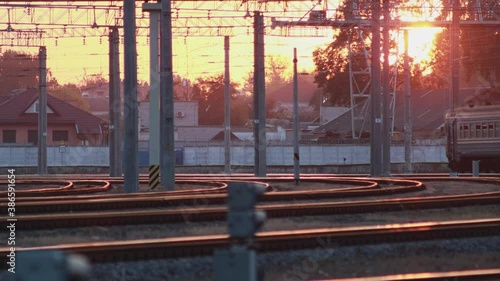 Russain passenger electric multiple unit train leaves the railway station at sunset. Passengers walk on the platform. Travel and tourism. Railroad carriage wagons going in daytime. photo