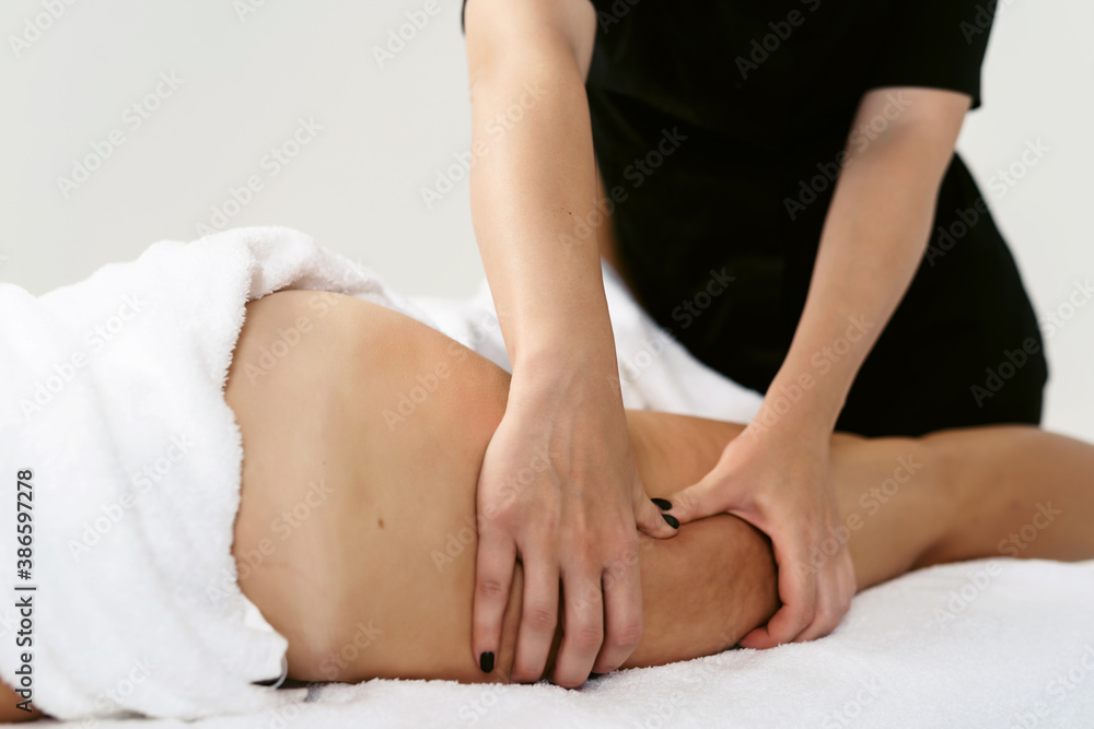 Fat burning massage. masseur making anti cellulite massage for young woman in wellness center or beauty salon. Perfect skin beauty concept Fat burning massage. masseur making anti cellulite massage for young woman in wellness center or beauty salon. Perfect skin beauty concept